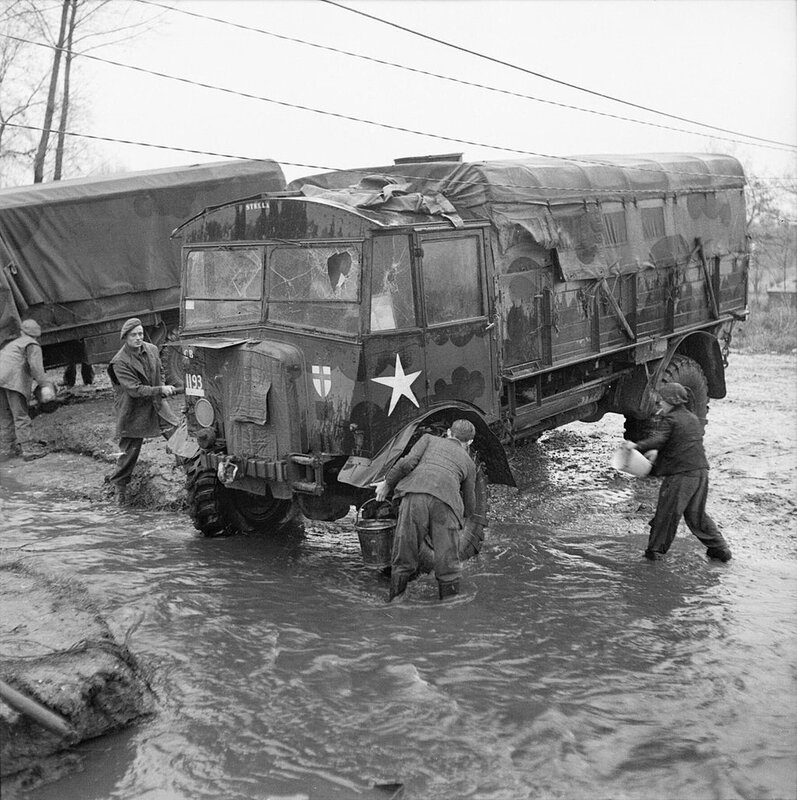 Dutch_boys_help_British_troops_clean_an_AEC_Matador_lorry_in_a_village_stream,_25_November_1944