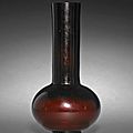 A ruby-red long neck glass vase, Qianlong four-character mark and of the period