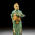 A green, yellow and cream glazed pottery figure of a monkey, 17th century 