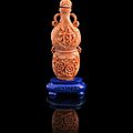 A coral snuff bottle on a lapis lazuli stand, 19th century