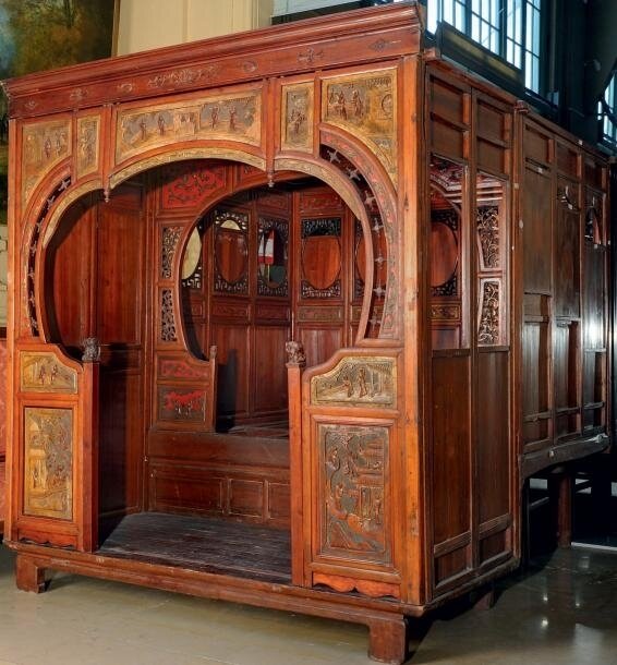 Lit de mariage en bois sculpté rehaussé de laque rouge redorée à décor