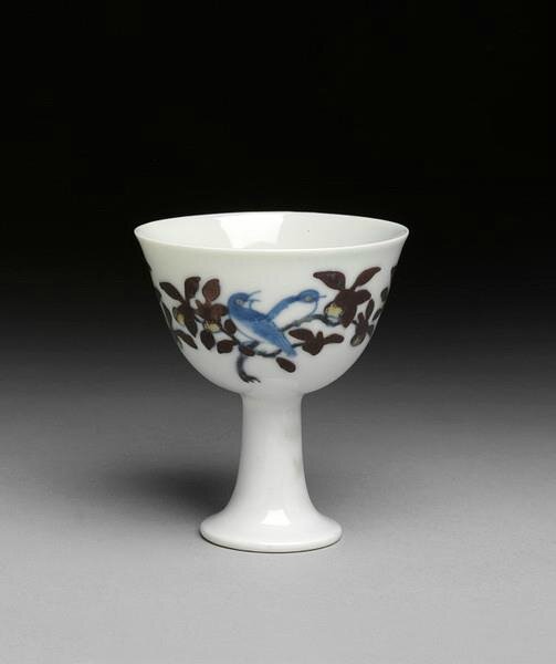 Stemcup, painted on the outside in underglaze blue and overglaze polychrome enamels in doucai style with two branches with large leaves and fruit and two pairs of birds. Chenghua mark and period (1465-1487), Ming dynasty. Jingdezhen kilns, south China. Hei