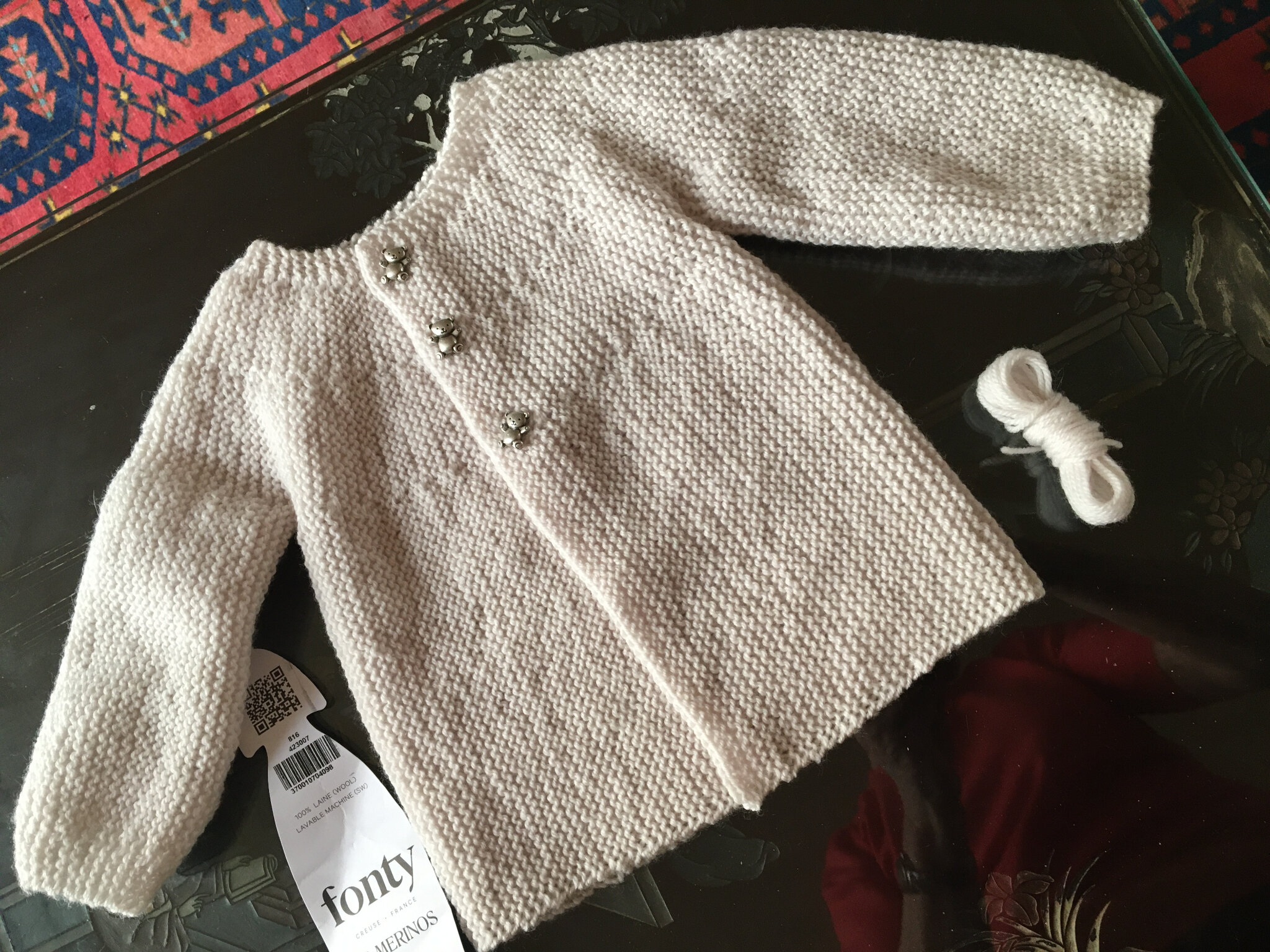 Brassière bébé rose en laine mérinos tricotée