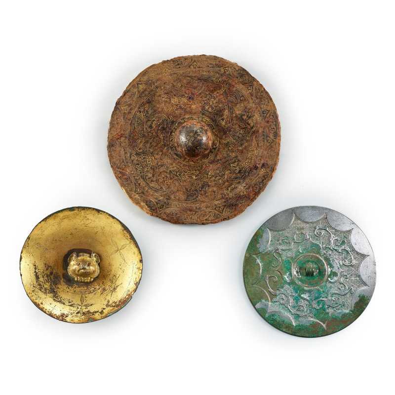 A rare gilt-bronze 'bear' circular plaque and two mirrors Warring States period - Han dynasty