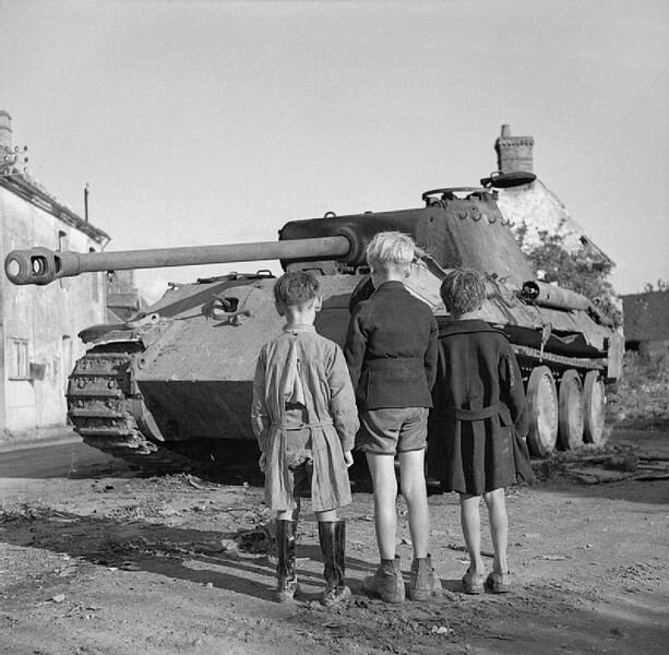 613px-Three_French_boys_looking_at_a_knocked-out_German_Panther_tank_in_the_Falaise_pocket, _Normandy, _25_August_1944__B9665